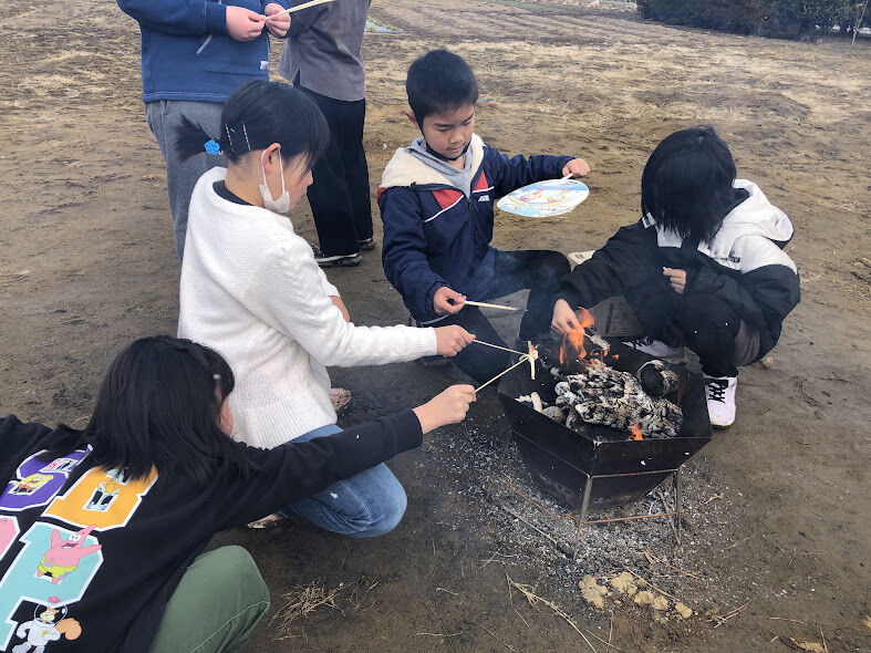 たき火で持ち寄ったお菓子を焼く子どもたち.jpg